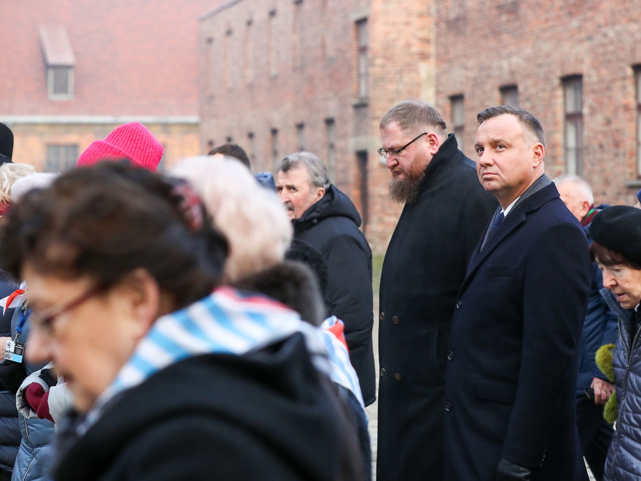 Przejście byłych więźniów, ich opiekunów oraz prezydenta Andrzeja Dudę i dyrektora Muzeum Auschwitz-Birkenau Piotra Cywińskiego przed Ścianę Śmierci 27 stycznia 2020 roku